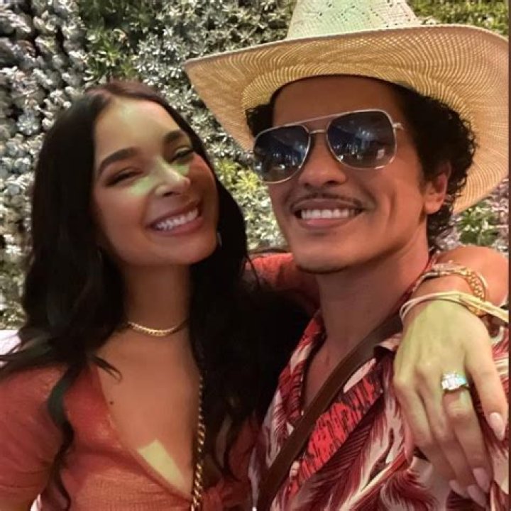 Bruno Mars and Jessica Cuban are smiling for a picture.